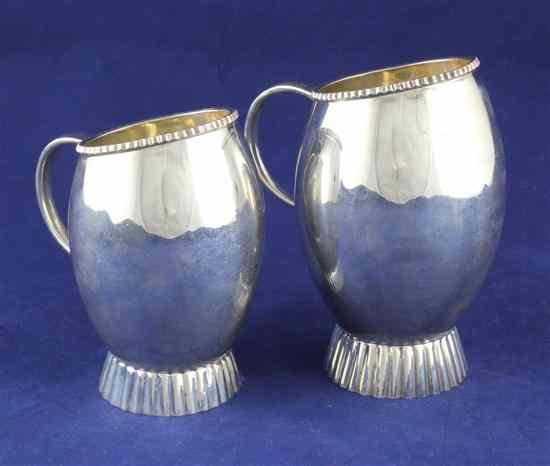 Appraisal: Two stylish graduated Indian white metal cream jugs of ovoid