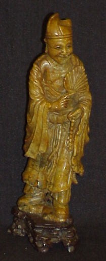 Appraisal: Chinese stone carving standing scholar holding fan and beads on