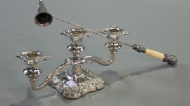 Appraisal: A three branched silverplated candelabrum together with a candle snuffer