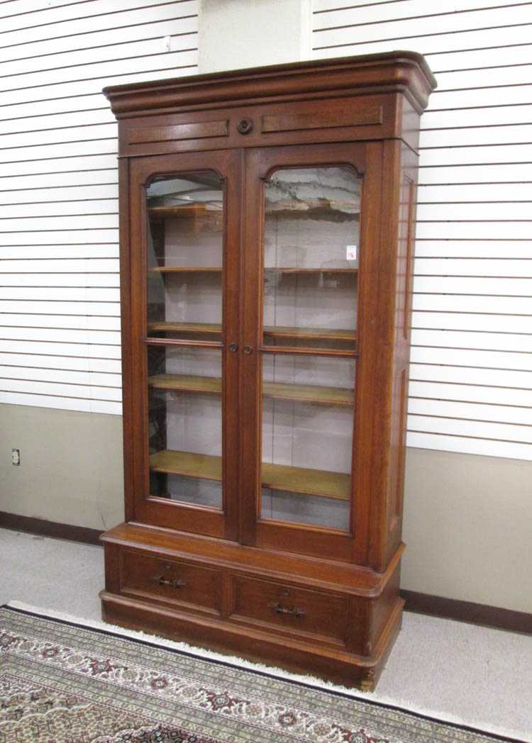 Appraisal: A VICTORIAN WALNUT CABINET BOOKCASE American c a tall double-door