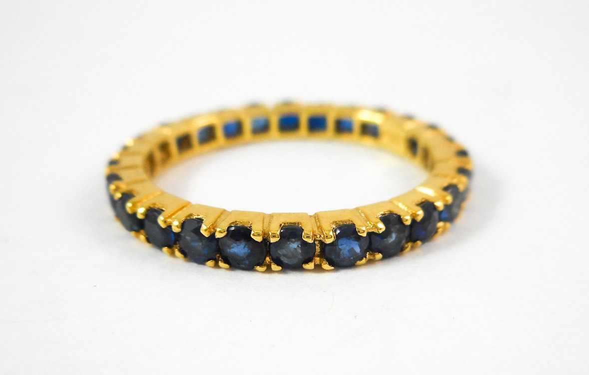 Appraisal: SAPPHIRE AND FOURTEEN KARAT GOLD ETERNITY RING The yellow gold