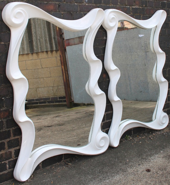 Appraisal: A pair of modern shaped mirrors with white scroll surrounds