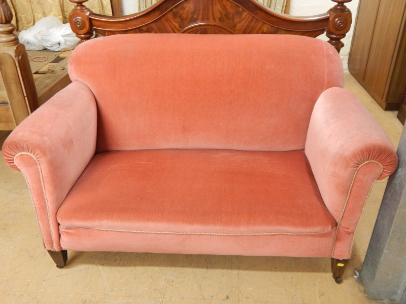 Appraisal: An Edwardian drop arm sofa upholstered in pink dralon on