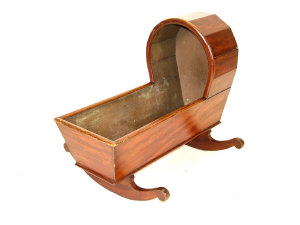 Appraisal: A simulated mahogany cradle the rounded hood with solid sides