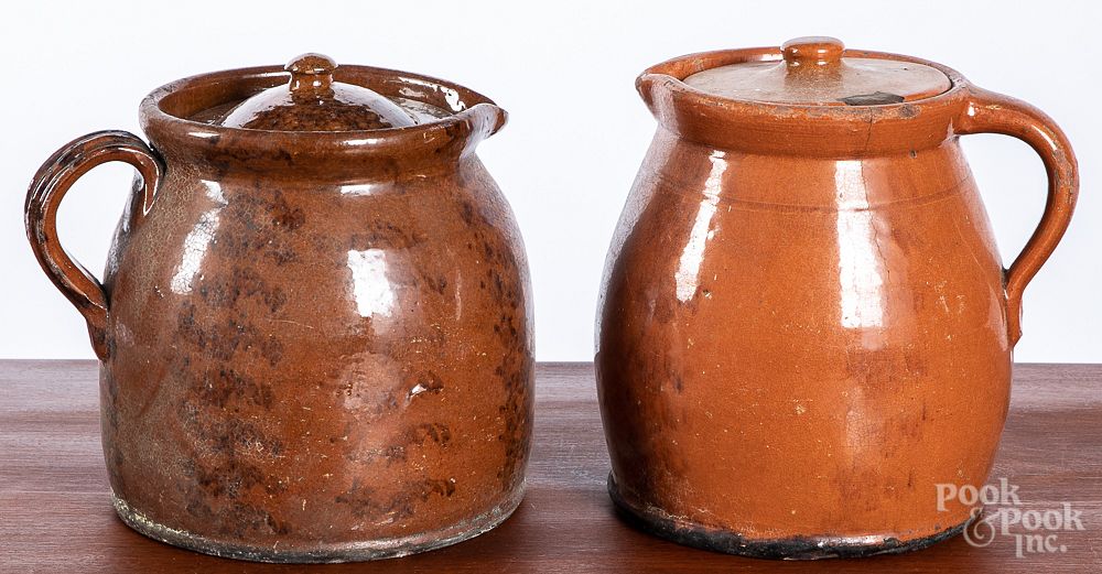 Appraisal: Two Pennsylvania redware lidded pitchers Two Pennsylvania redware lidded pitchers