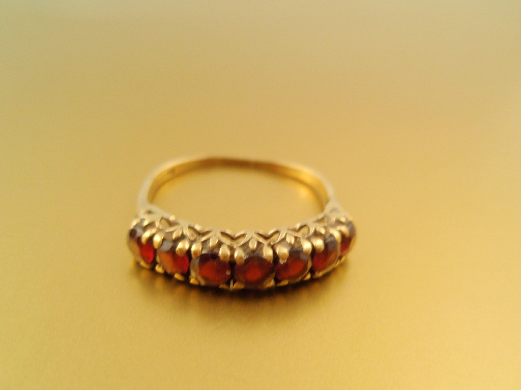 Appraisal: A ct gold garnet set ring seven stones in line