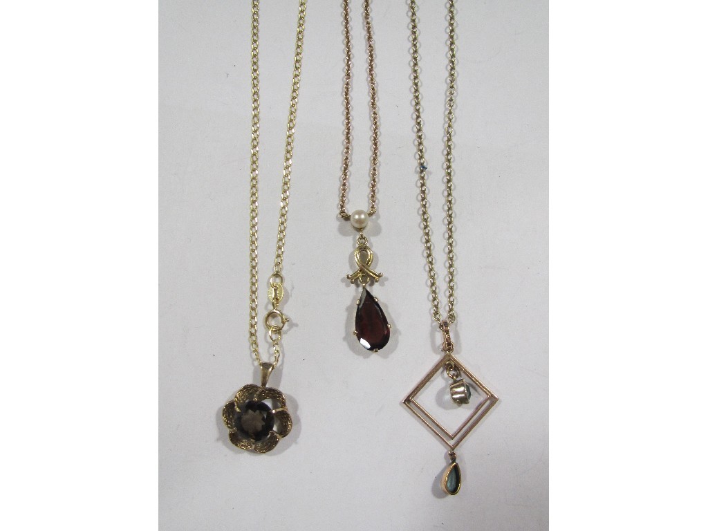 Appraisal: Three gold pendants one with garnet one with smokey topaz