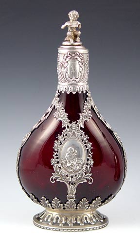 Appraisal: GERMAN SILVER OVERLAY RUBY GLASS DECANTER BOTTLE WITH FIGURAL PAN