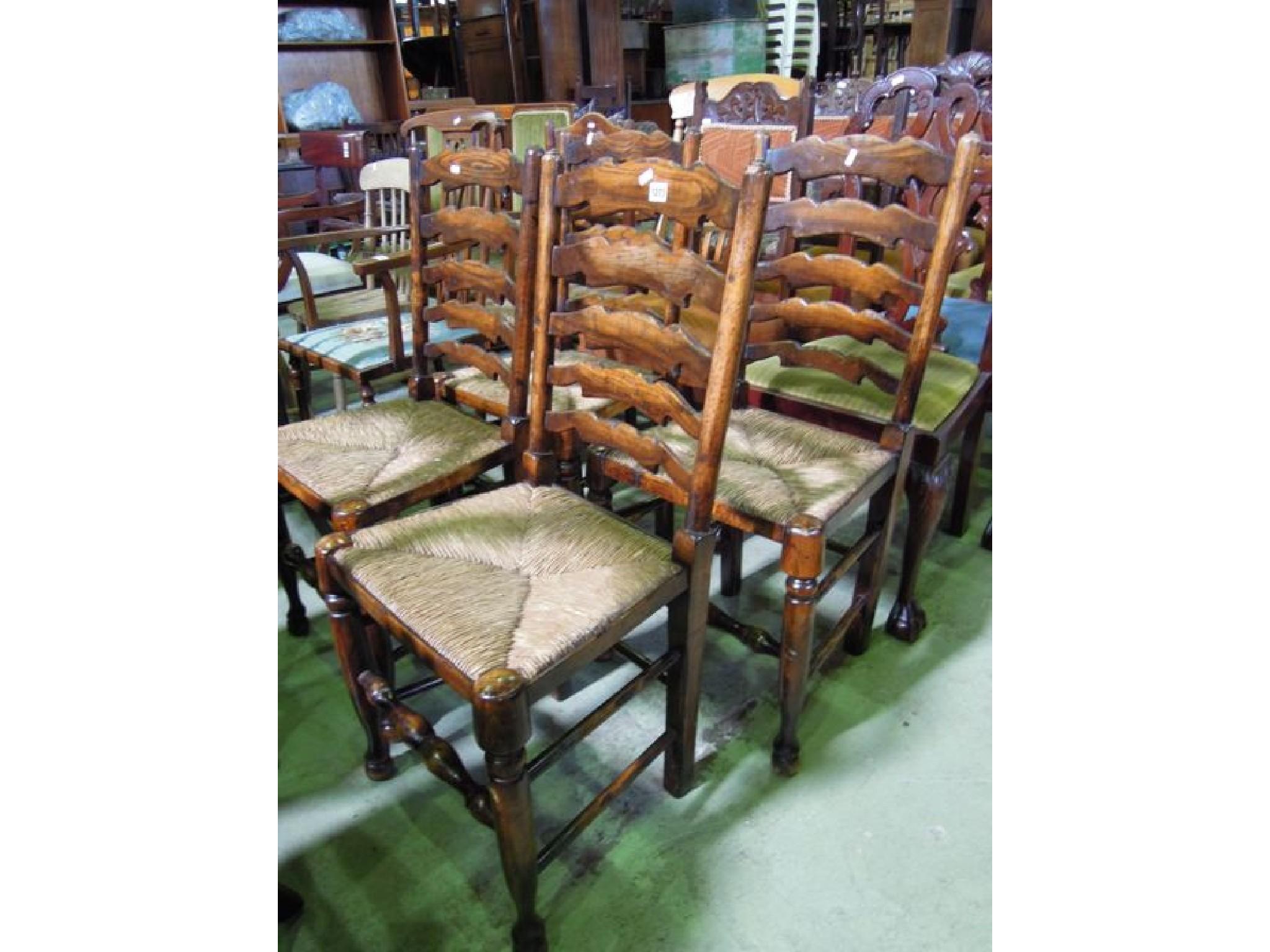 Appraisal: A set of four good quality reproduction oak ladderback dining