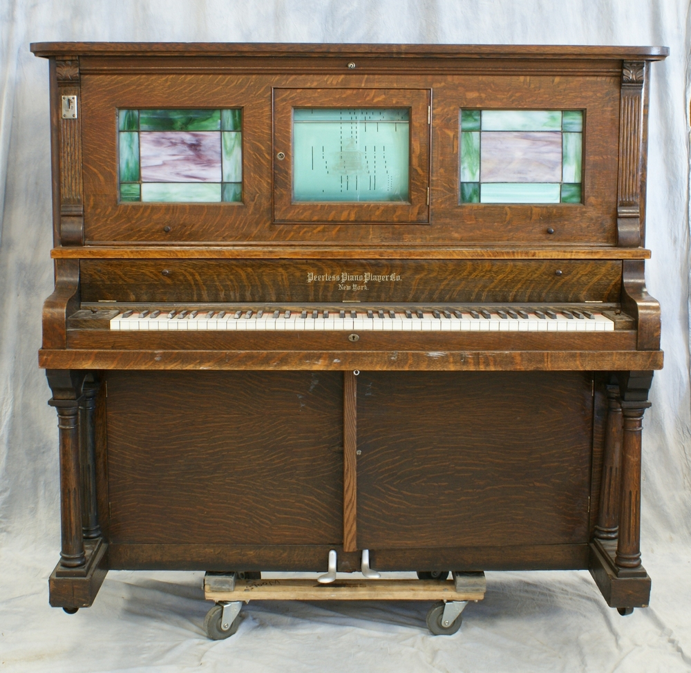 Appraisal: Peerless coin operated oak player piano with stained glass panels