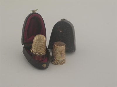 Appraisal: A Victorian gold thimble with an engraved diaperwork base and