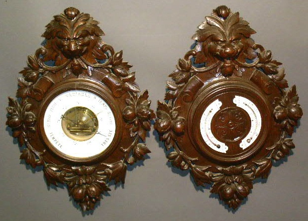 Appraisal: Pair of carved Black Forest weather gauges late thc with