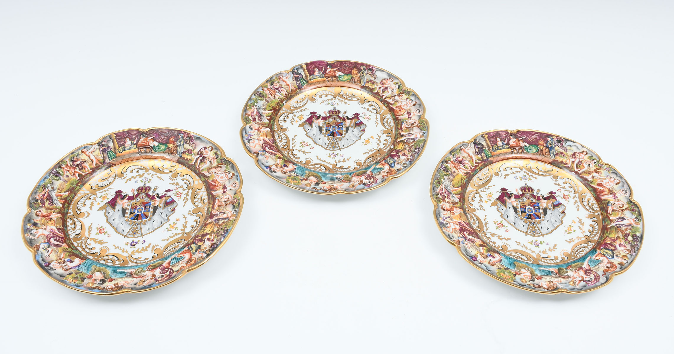 Appraisal: CAPODIMONTE FIGURAL CHARGERS Three Capodimonte plates having raised figural rims