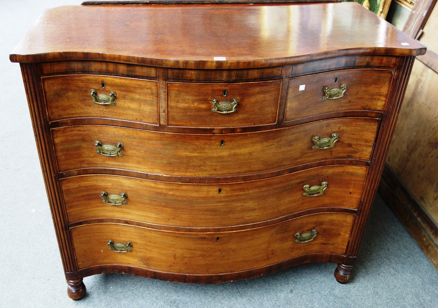 Appraisal: A George III mahogany serpentine chest of three short over