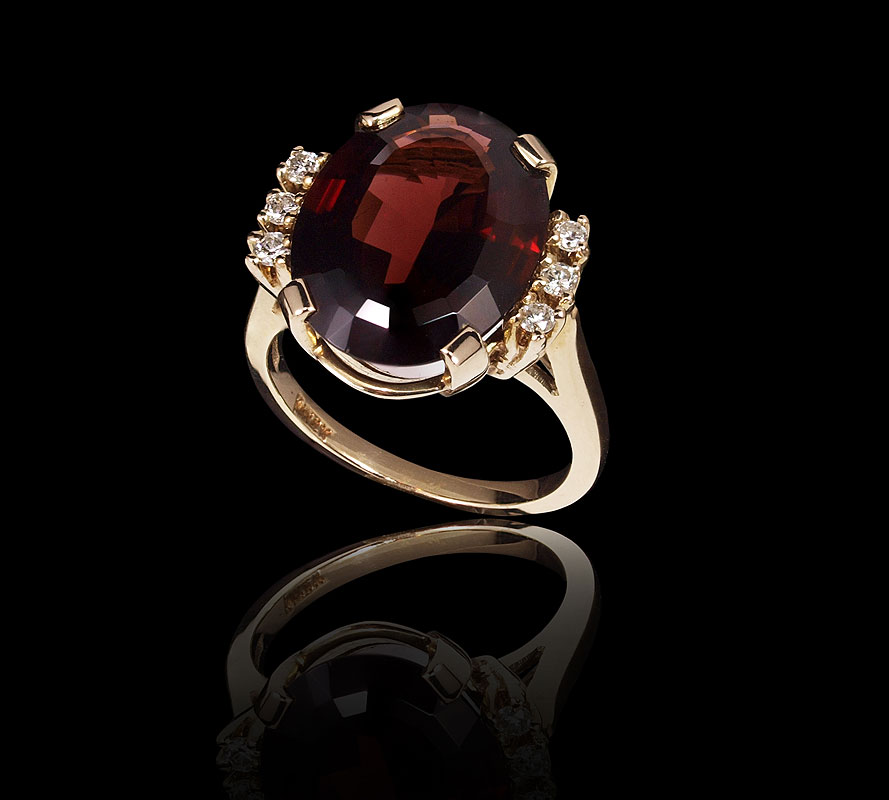 Appraisal: MOZAMBIQUE GARNET AND DIAMOND RING K yellow gold ring centers