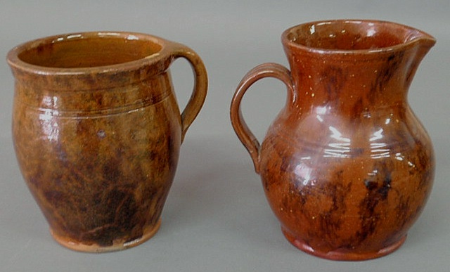 Appraisal: Redware pitcher with a strap handle and mottled decoration h