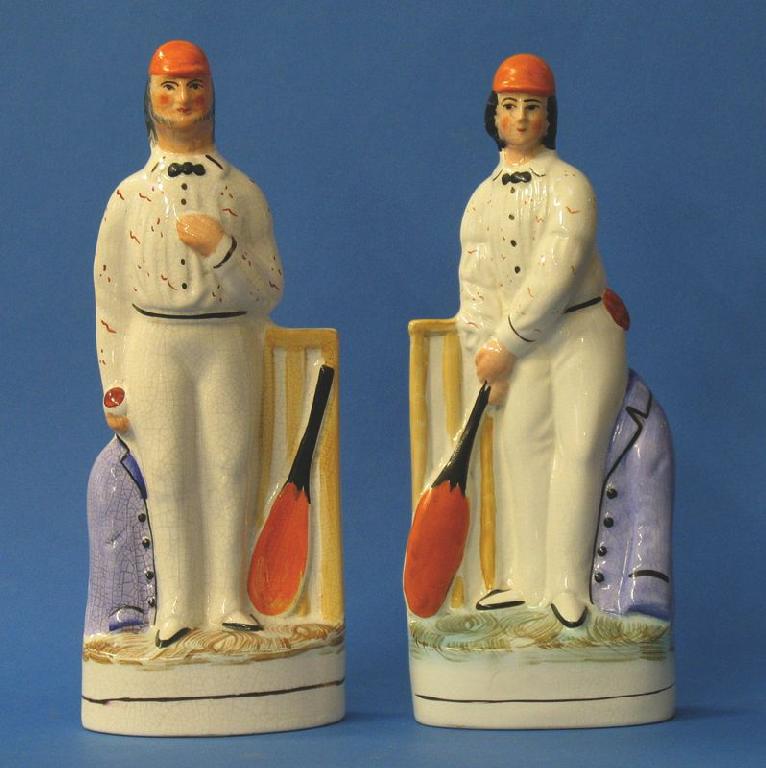 Appraisal: A PAIR OF STAFFORDSHIRE POTTERY FIGURES OF CRICKETERS modelled holding