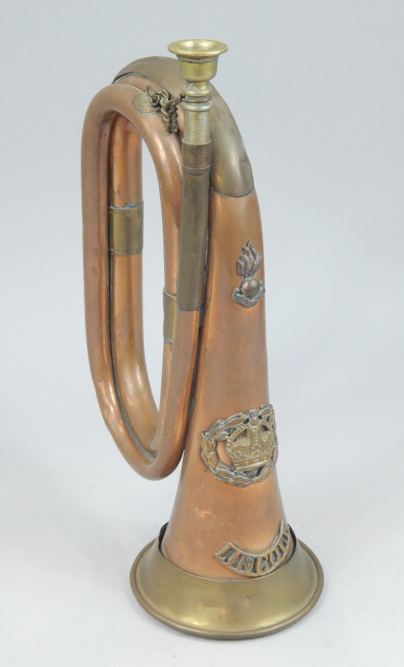 Appraisal: A brass and copper bugle applied with military style badges