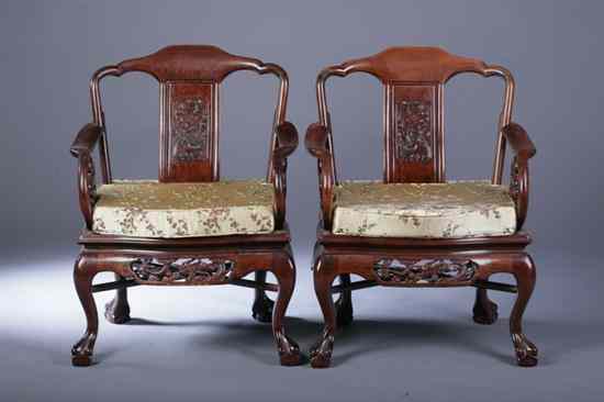 Appraisal: FOUR CHINESE CARVED ROSEWOOD OPEN-ARM CHAIRS Dragon-form handles En suite