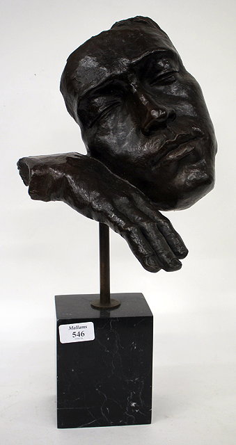 Appraisal: A CONTEMPORARY BRONZE SCULPTURE DEPICTING A FACE RESTING ON A