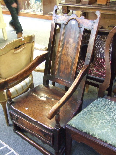 Appraisal: An early th century elm chair the arch panel back