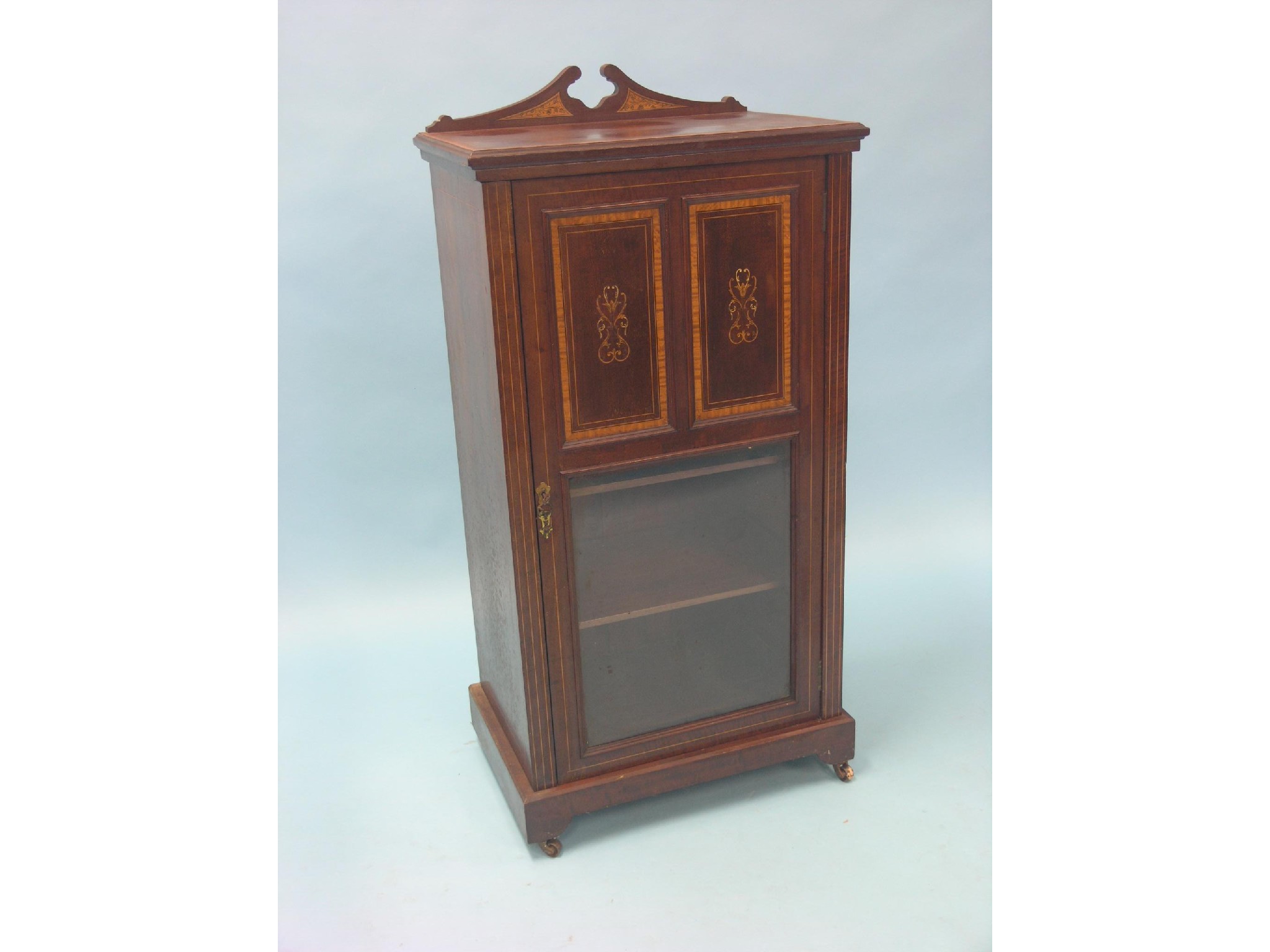 Appraisal: An Edwardian inlaid mahogany music cabinet single glazed door with