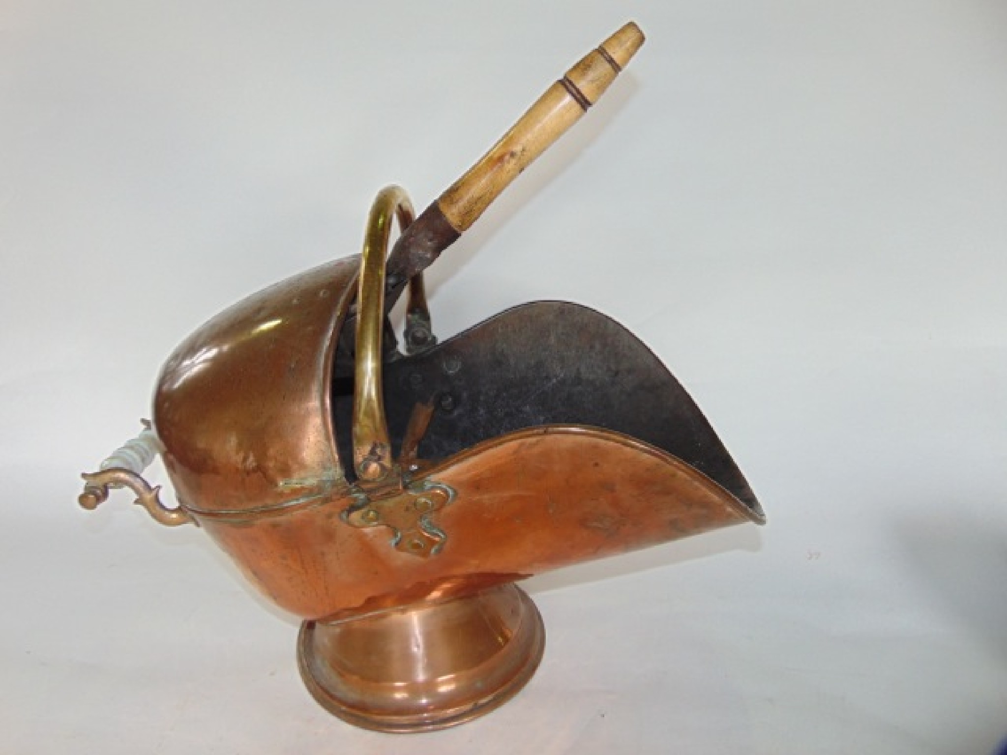 Appraisal: An antique copper coal scuttle with applied looping handle accommodating