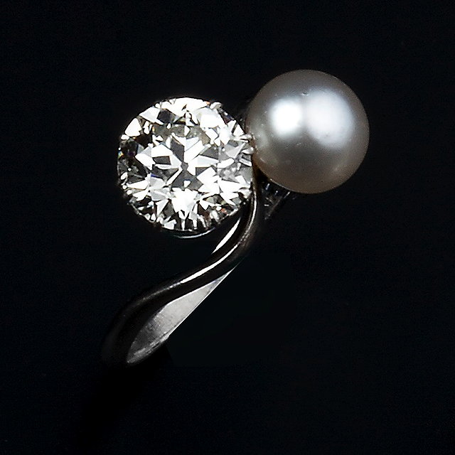 Appraisal: A DIAMOND AND PEARL CROSSOVER RING obliquely claw set with