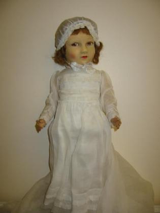 Appraisal: A felt faced doll with moulded and painted face short