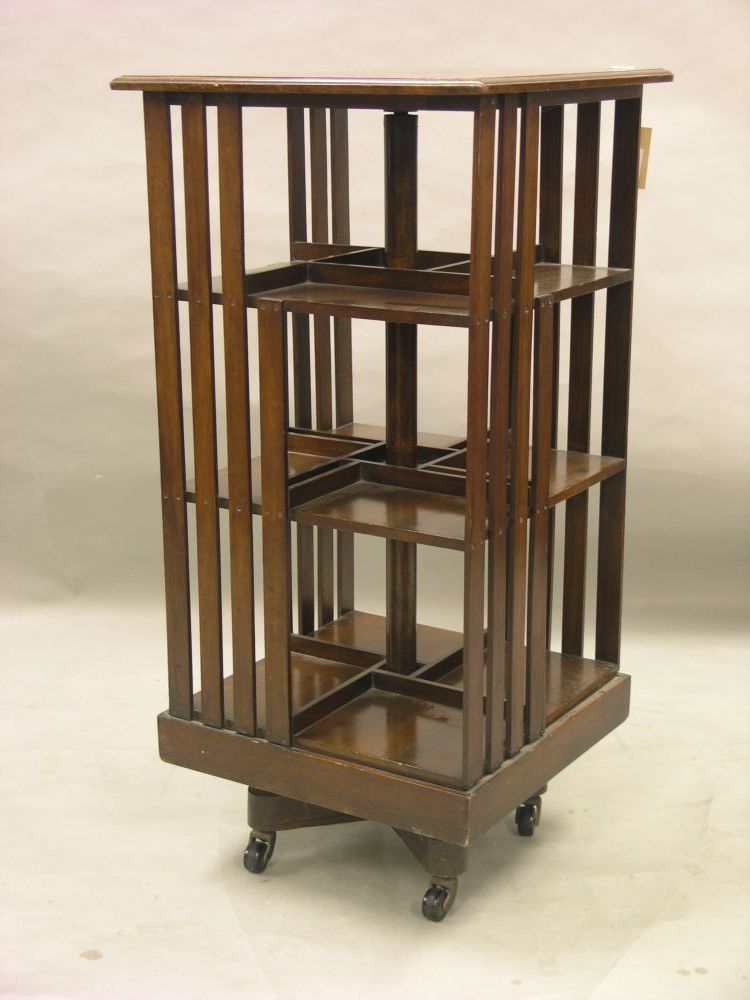 Appraisal: An Edwardian walnut revolving bookcase with three slatted tiers on