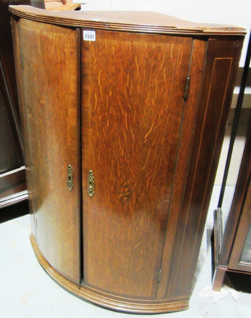 Appraisal: A th century oak bowfront corner cabinet