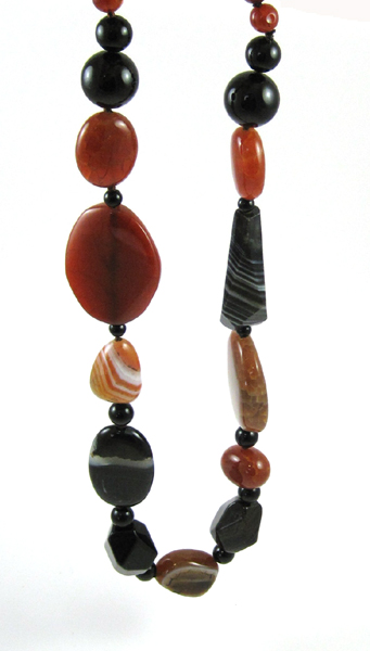 Appraisal: AGATE BEAD NECKLACE with carved and shaped black and amber