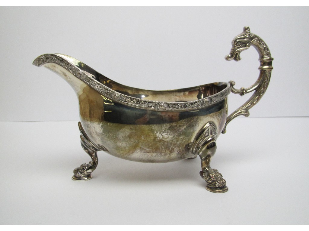 Appraisal: A silver sauceboat with Celtic decoration and dragon's head handle