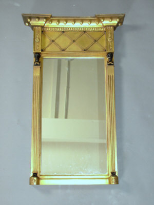 Appraisal: A gilded Empire style pier mirror with inverted breakfront cavetto