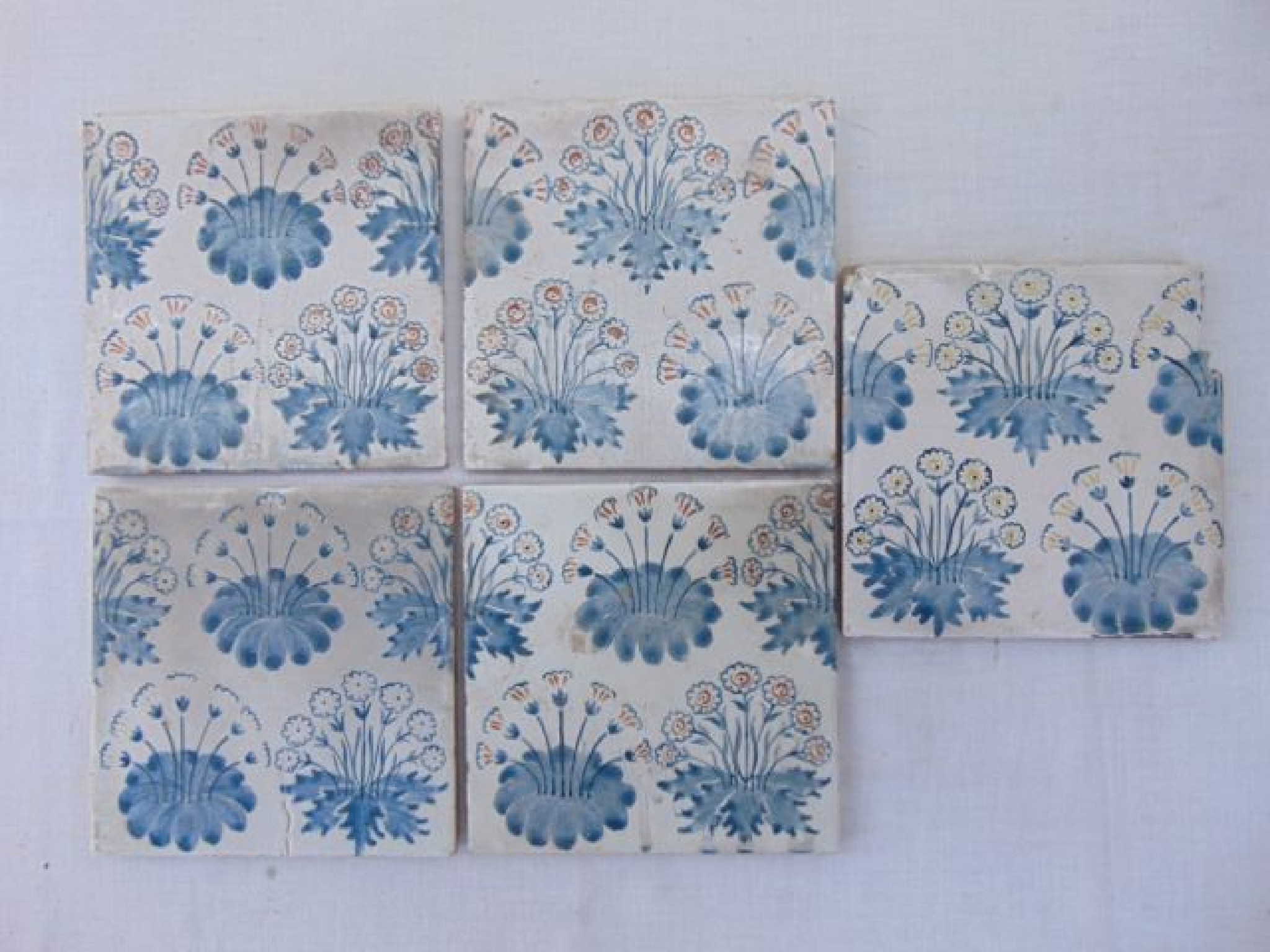 Appraisal: A collection of five pottery tiles with painted daisy spray