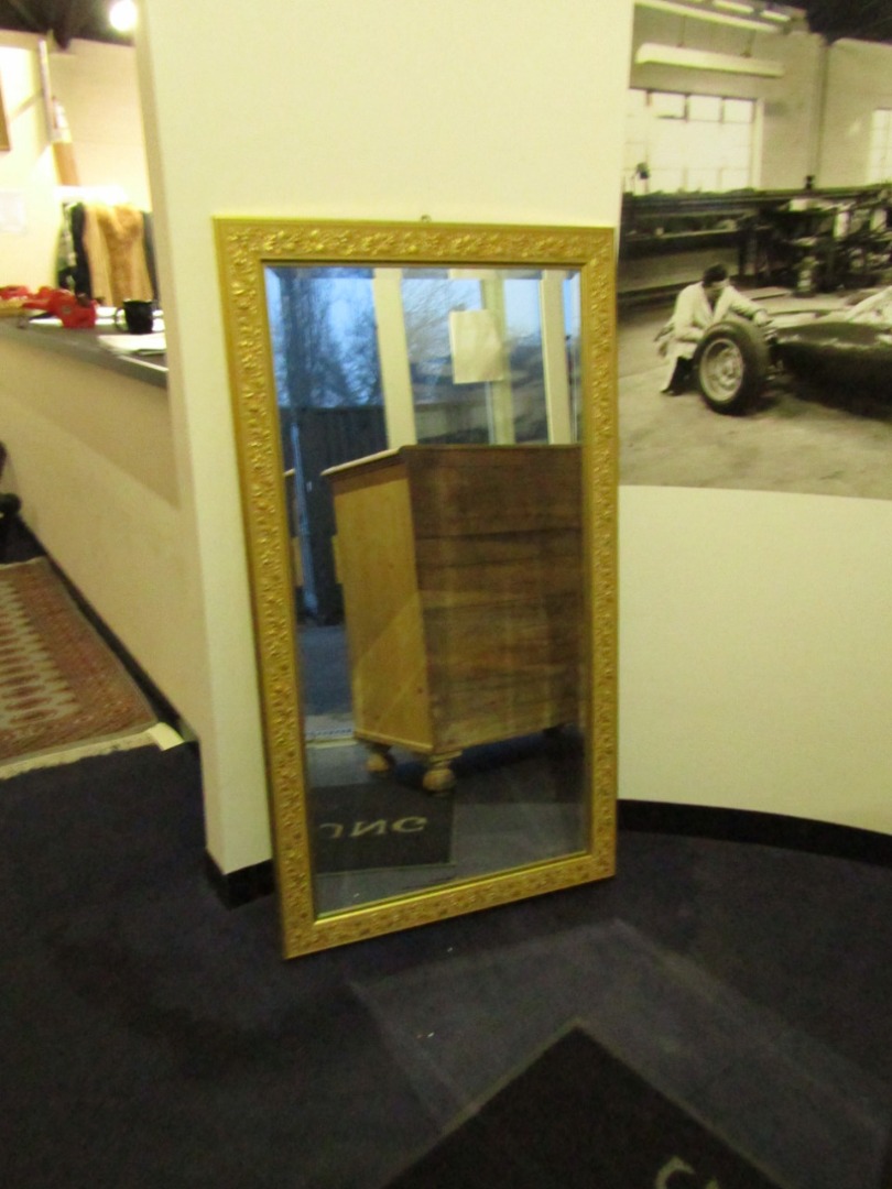 Appraisal: A rectangular gilt plaster wall mirror embossed with a border