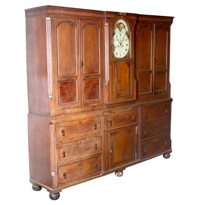 Appraisal: A George III oak housekeeper's cupboard incorporating an eight-day clock