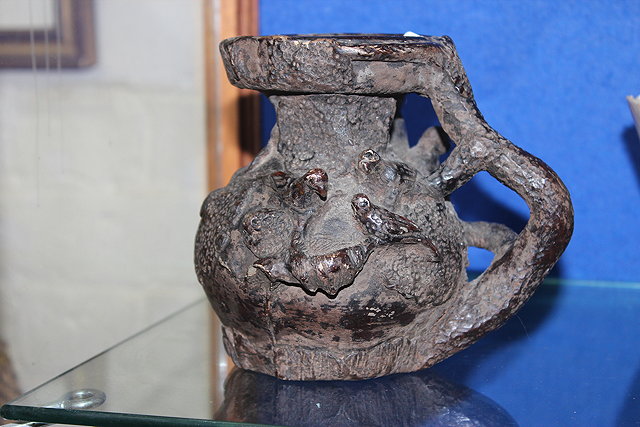 Appraisal: AN UNUSUAL GROTESQUE POTTERY VESSEL scrolling vine handles with monkeys