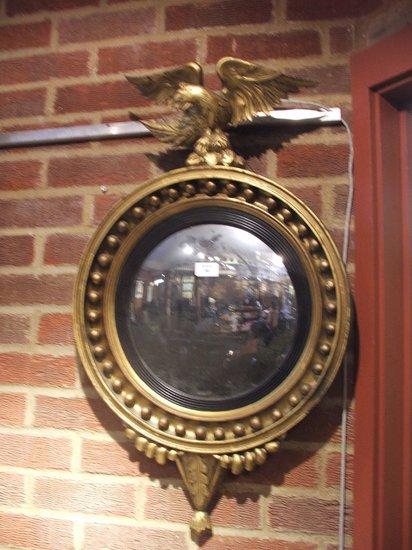 Appraisal: A REGENCY GILTWOOD CONVEX MIRROR with ebony slip sphere ornament