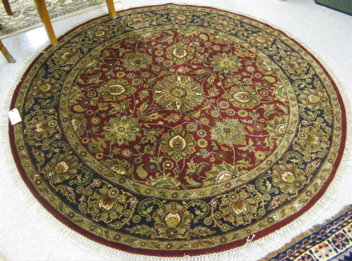 Appraisal: A ROUND ORIENTAL ACCENT RUG overall floral decoration on alizarin