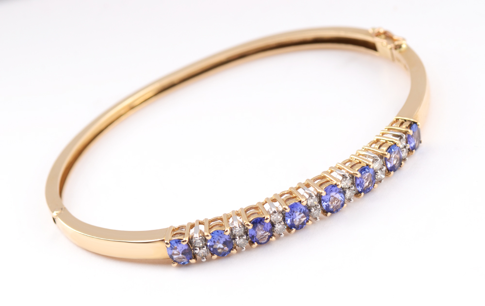 Appraisal: TANZANITE AND DIAMOND BRACELET Signed Cordova k yellow gold hinged