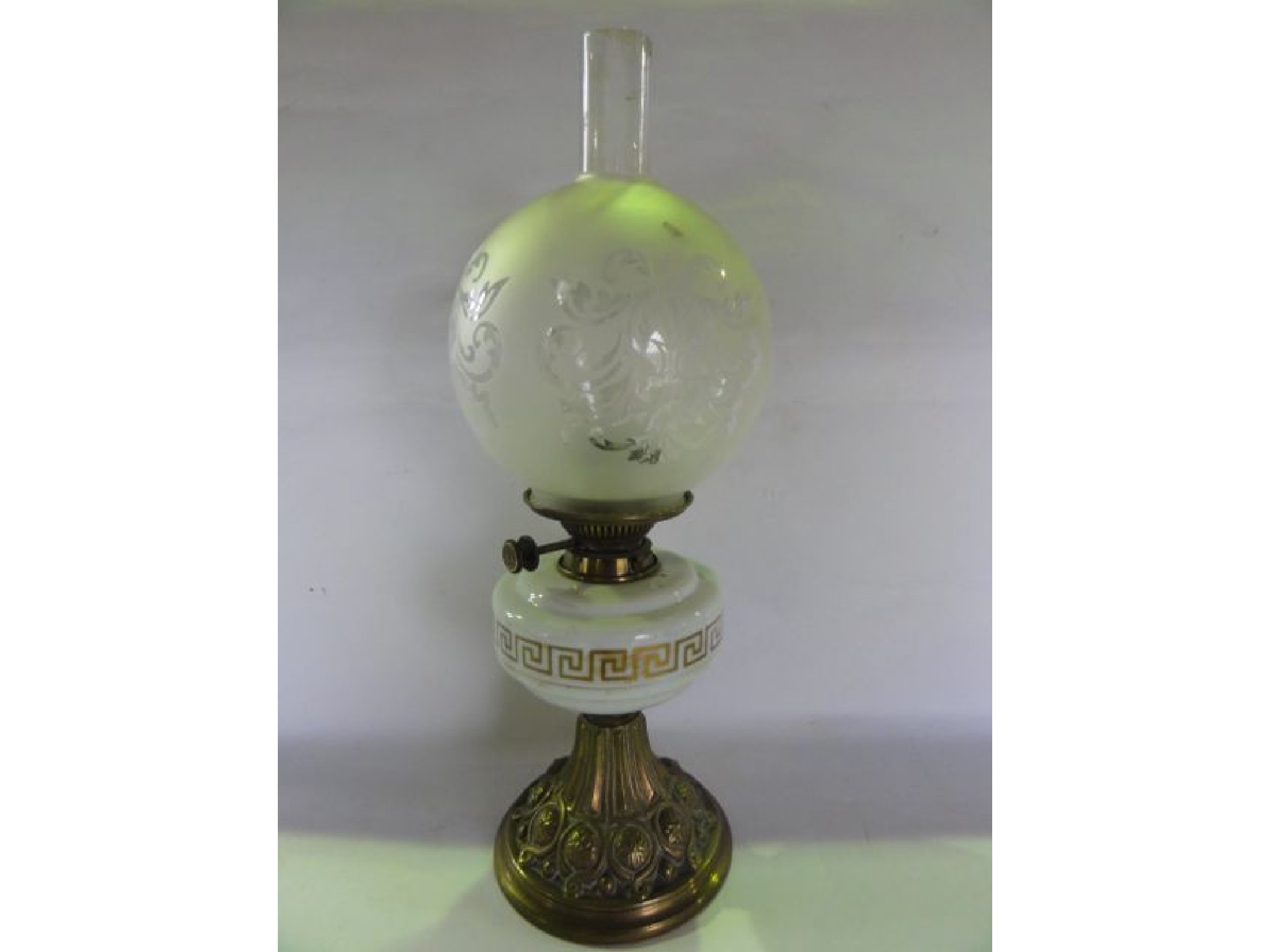 Appraisal: A Victorian oil lamp raised on an embossed brass foot