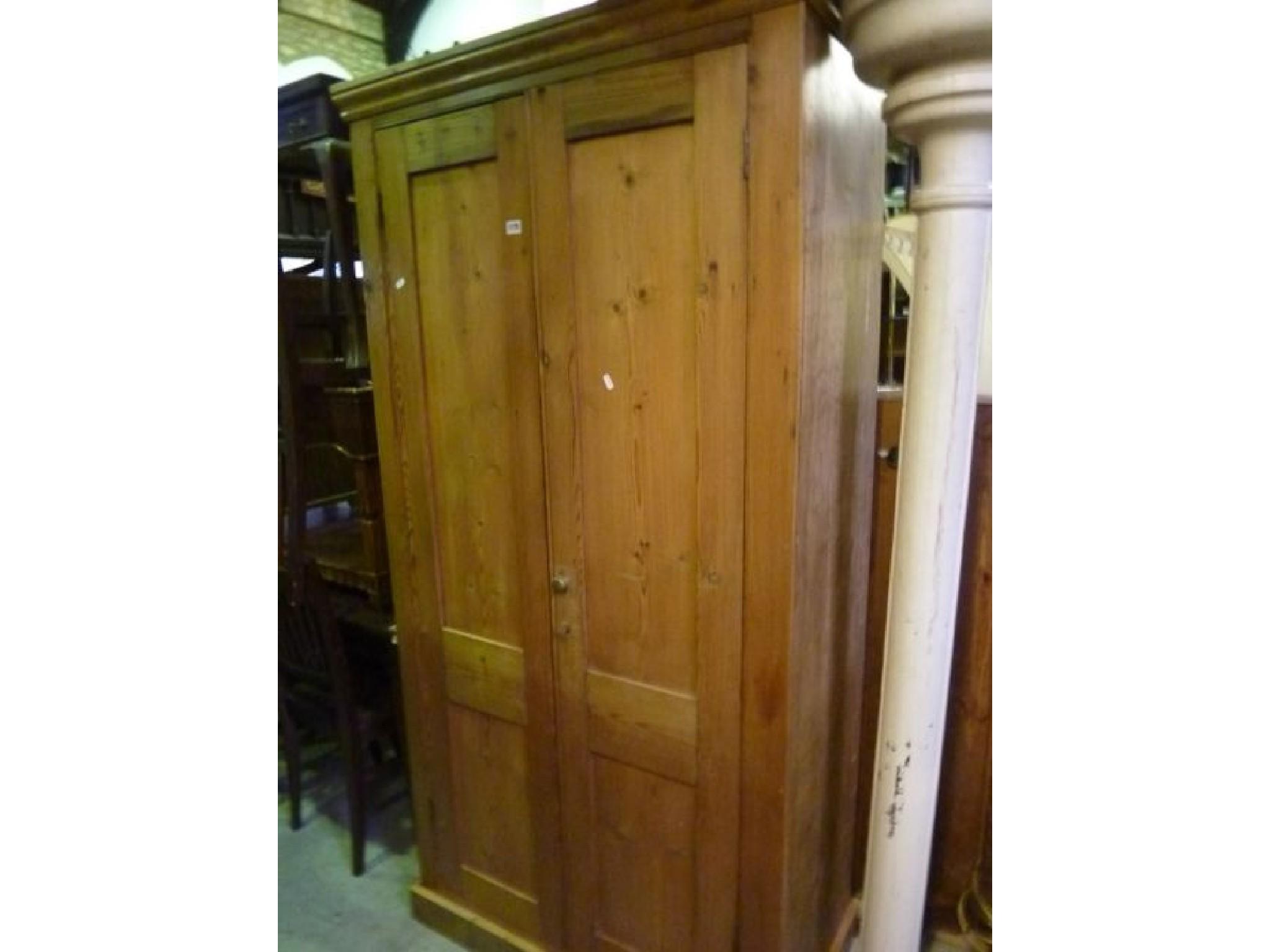 Appraisal: A stripped and waxed pine side cupboard enclosed by a