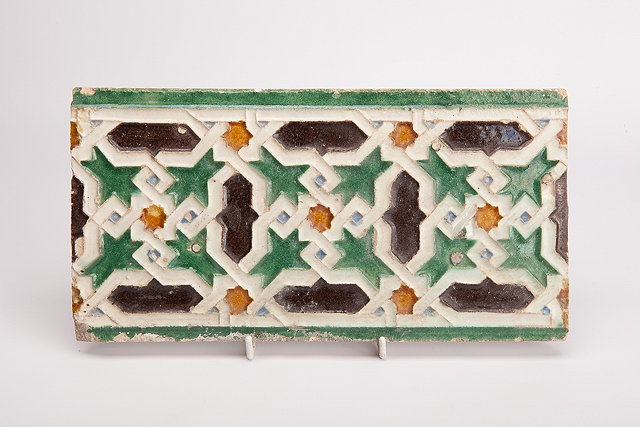 Appraisal: AN ISLAMIC POTTERY TILE FRAGMENT part of a frieze with