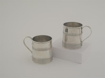 Appraisal: A pair of small George IV reeded mugs with scroll