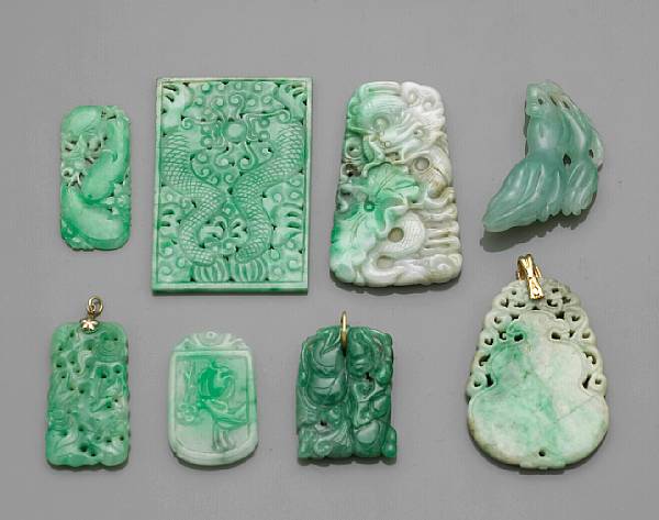 Appraisal: Eight jadeite pendants The first a green jadeite pendant carved