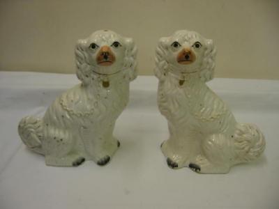 Appraisal: A PAIR OF STAFFORSHIRE POTTERY SPANIELS modelled seated in white