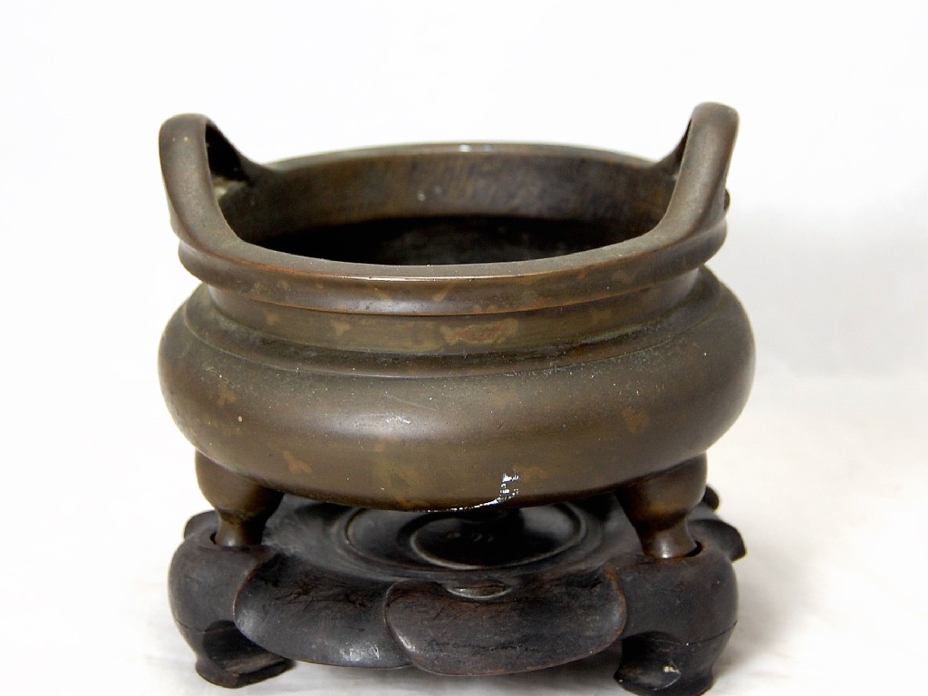 Appraisal: A th century Chinese bronze two handled incense bowl on