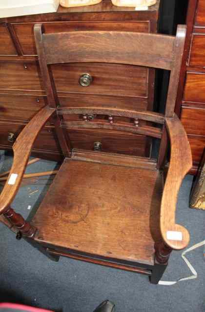 Appraisal: A TH CENTURY OAK COMMODE ARMCHAIR a Welsh oak armchair