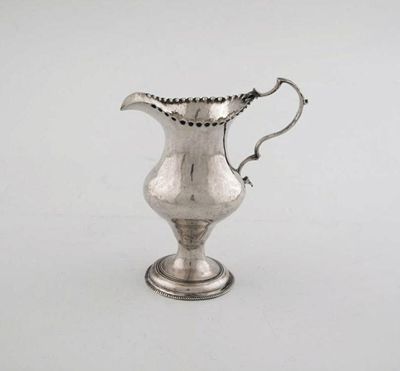 Appraisal: A George III baluster cream jug with a punch beaded